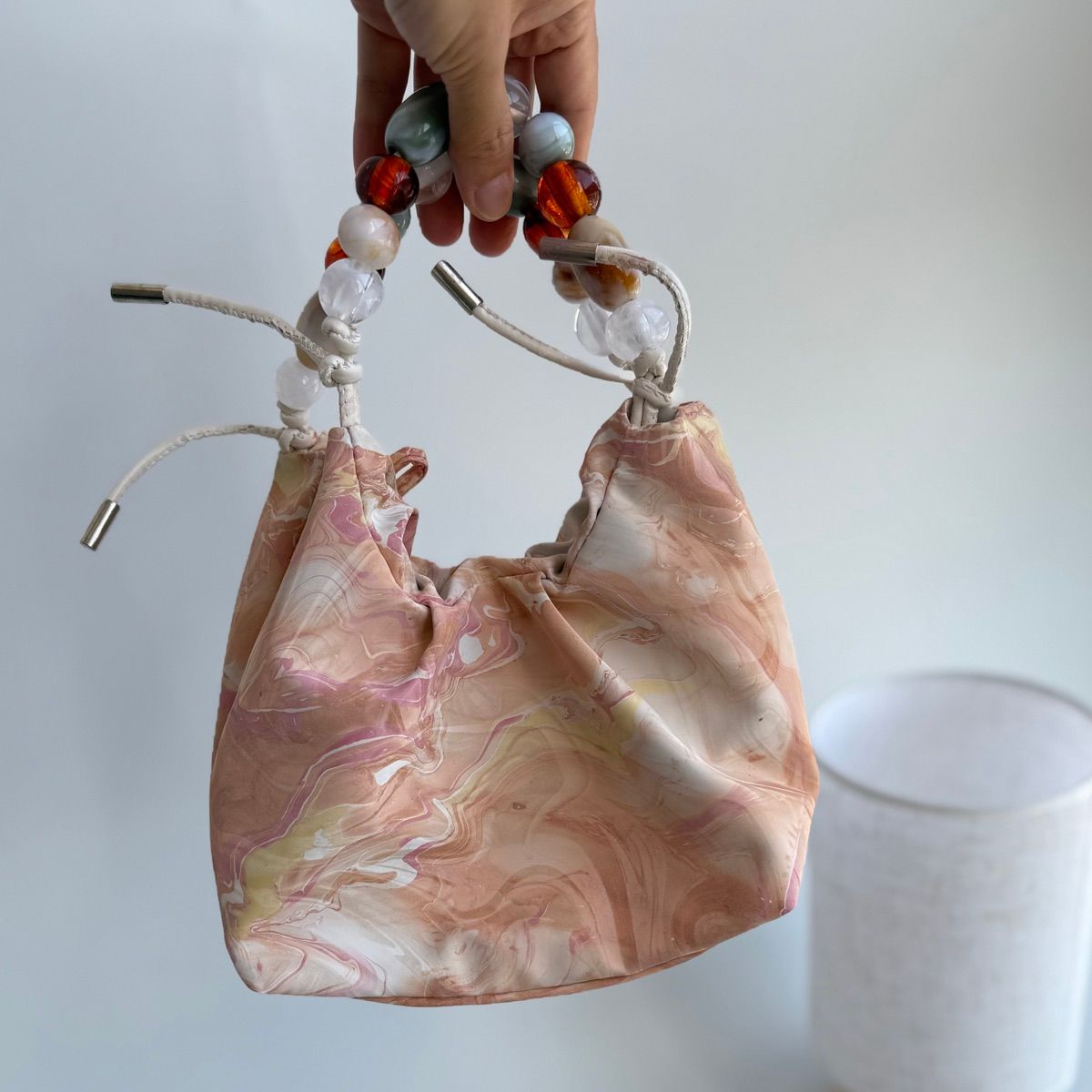 Peach Cloud original studio view showing the beaded handle and cord closures