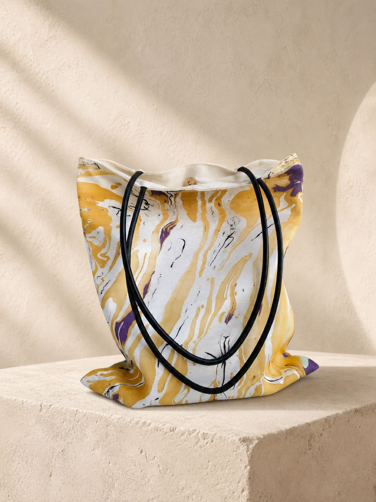 Golden Rain yellow and lavender velvet shoulder bag on a cream stone plinth