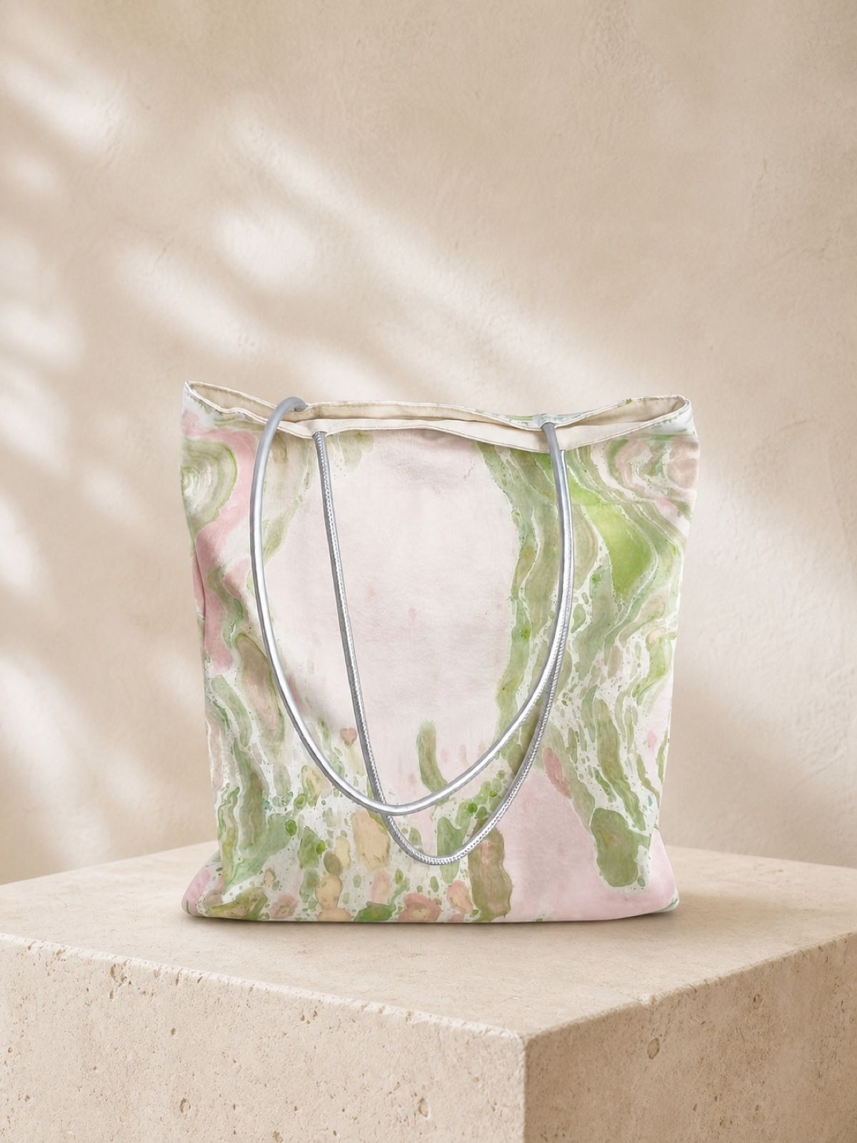 Meadow Mist pink and green velvet shoulder bag on a warm stone plinth