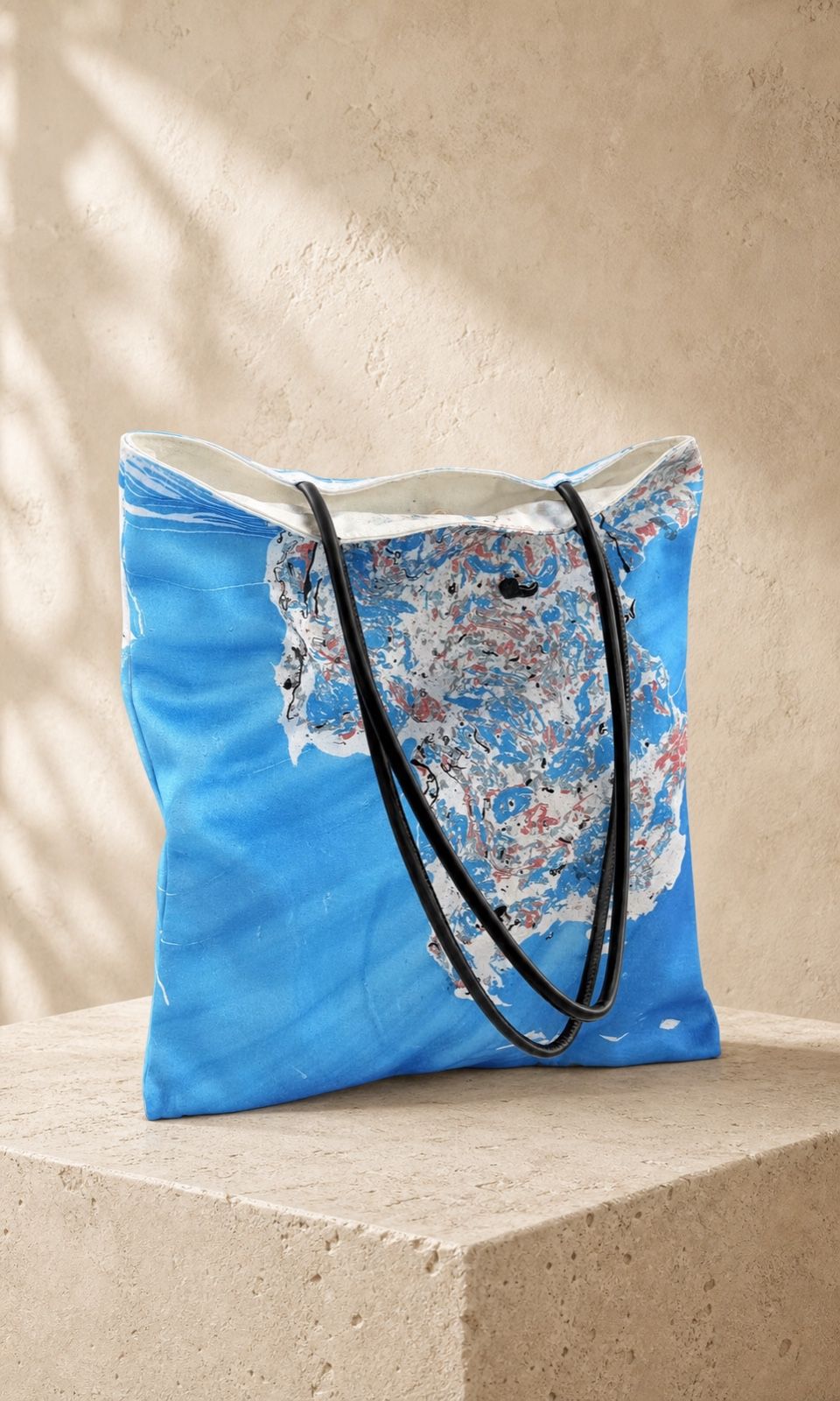 Cobalt Bloom blue velvet shoulder bag on a warm travertine plinth
