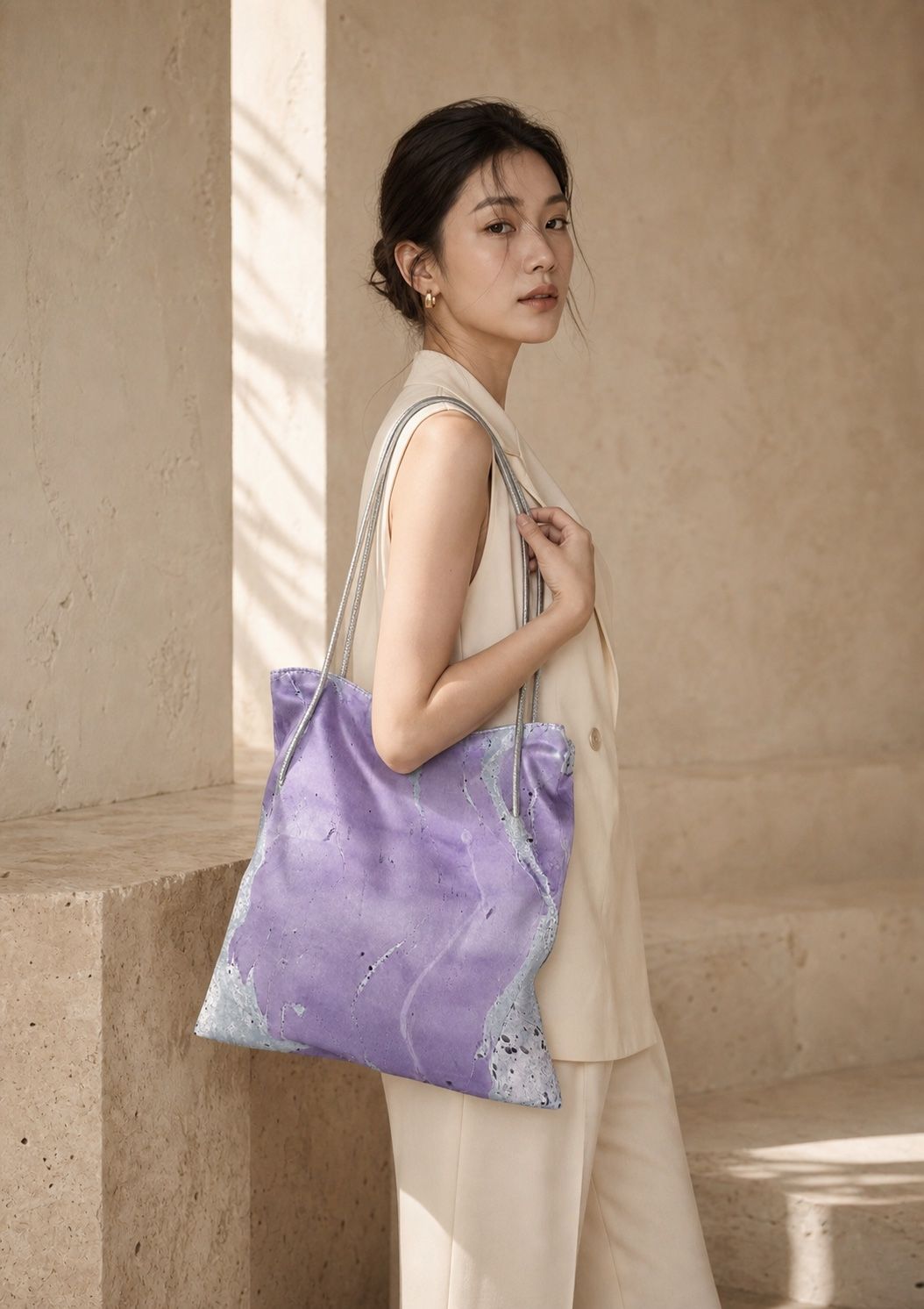 Model carrying a large violet floating-lacquer shoulder bag in a warm stone interior